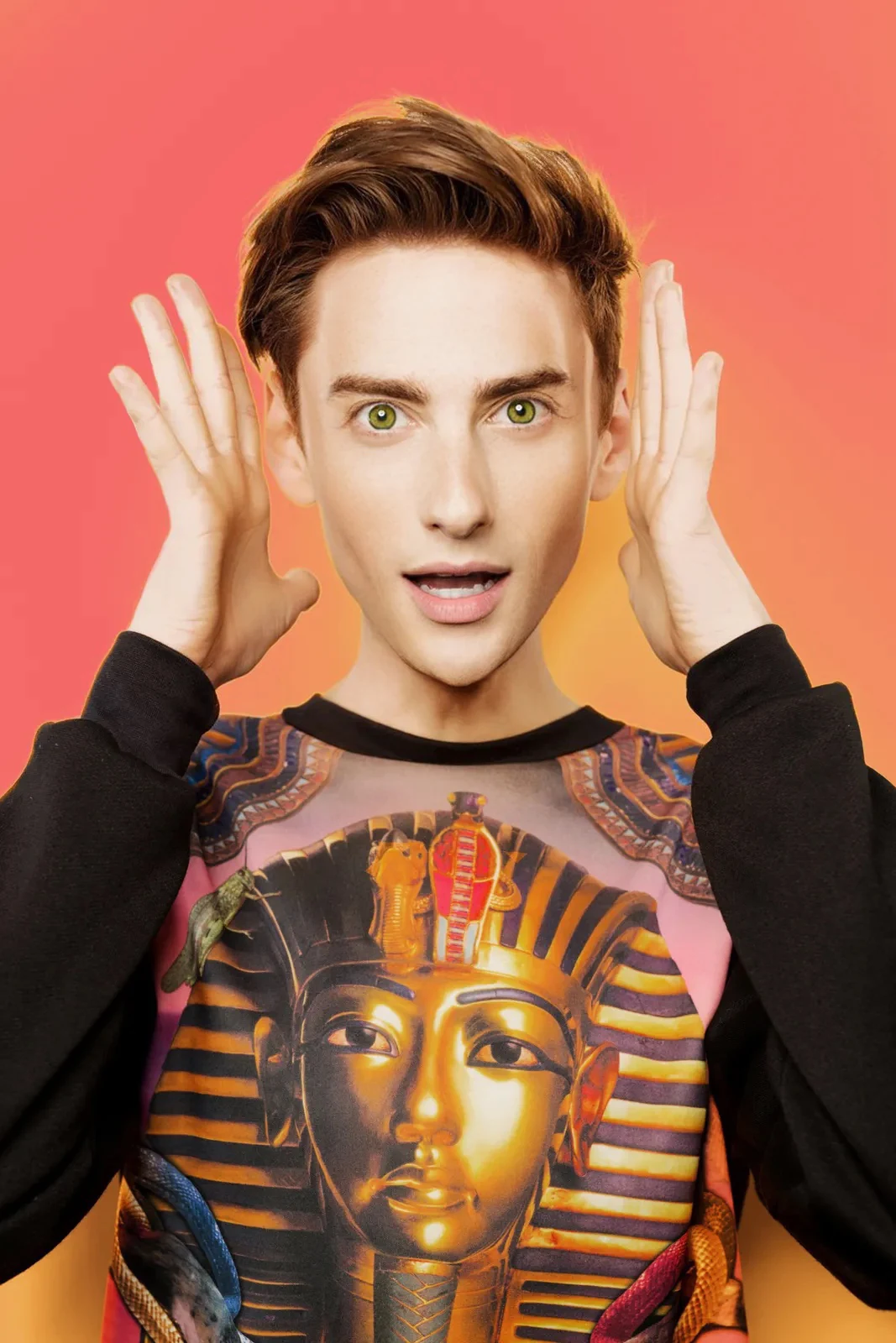 Joshua in a printed top against a coral background